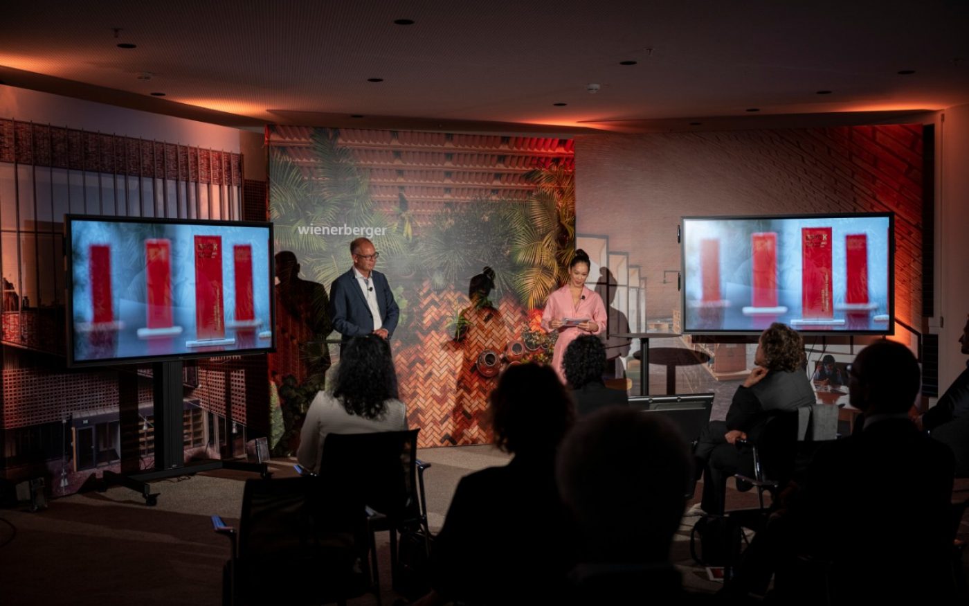 Heimo Scheuch and Miriam Hie at the Ceremony; trophies on screen