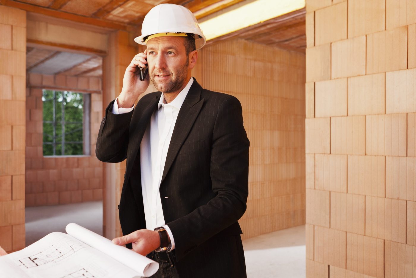 Building professional with mobile phone and blueprint inside building-shell