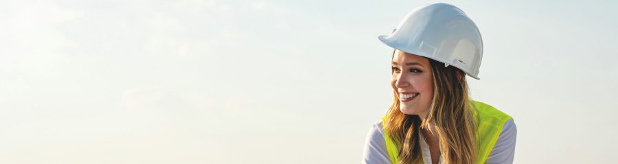 Djevojka s kacigom stoji na gradilištu