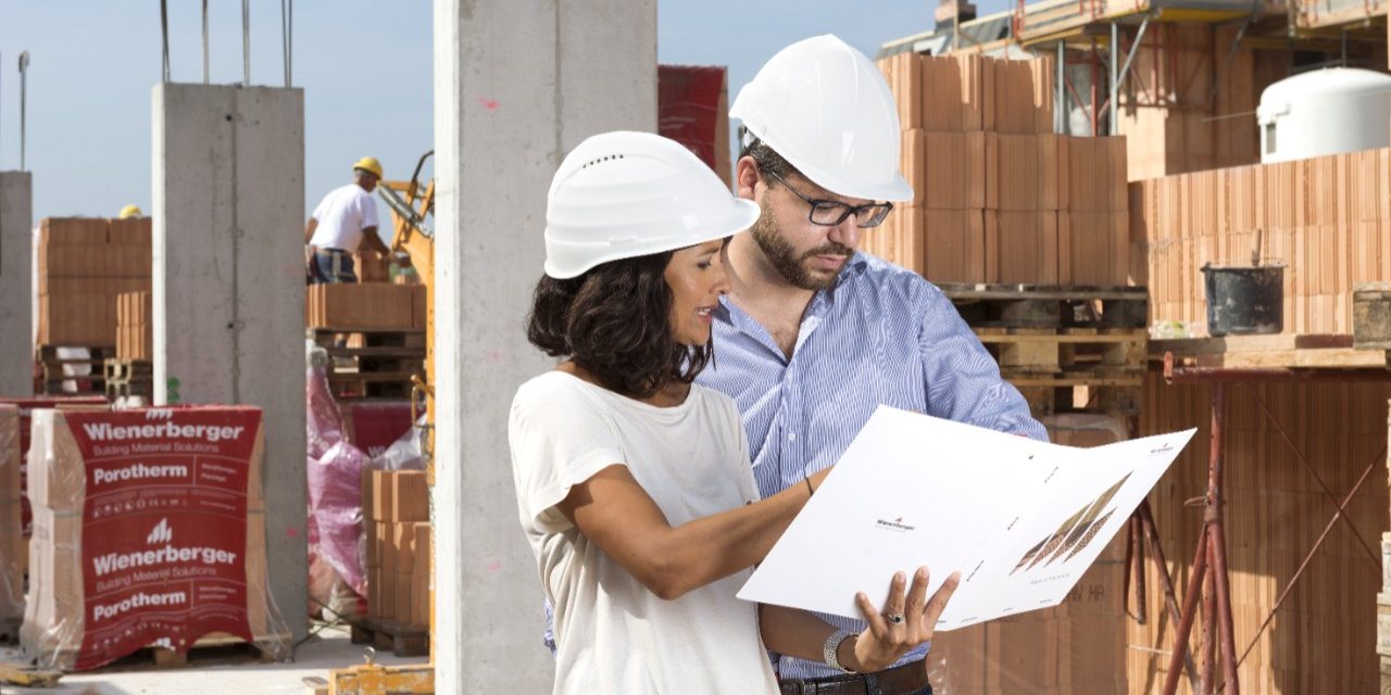 Architects with project folder surveilling construction site