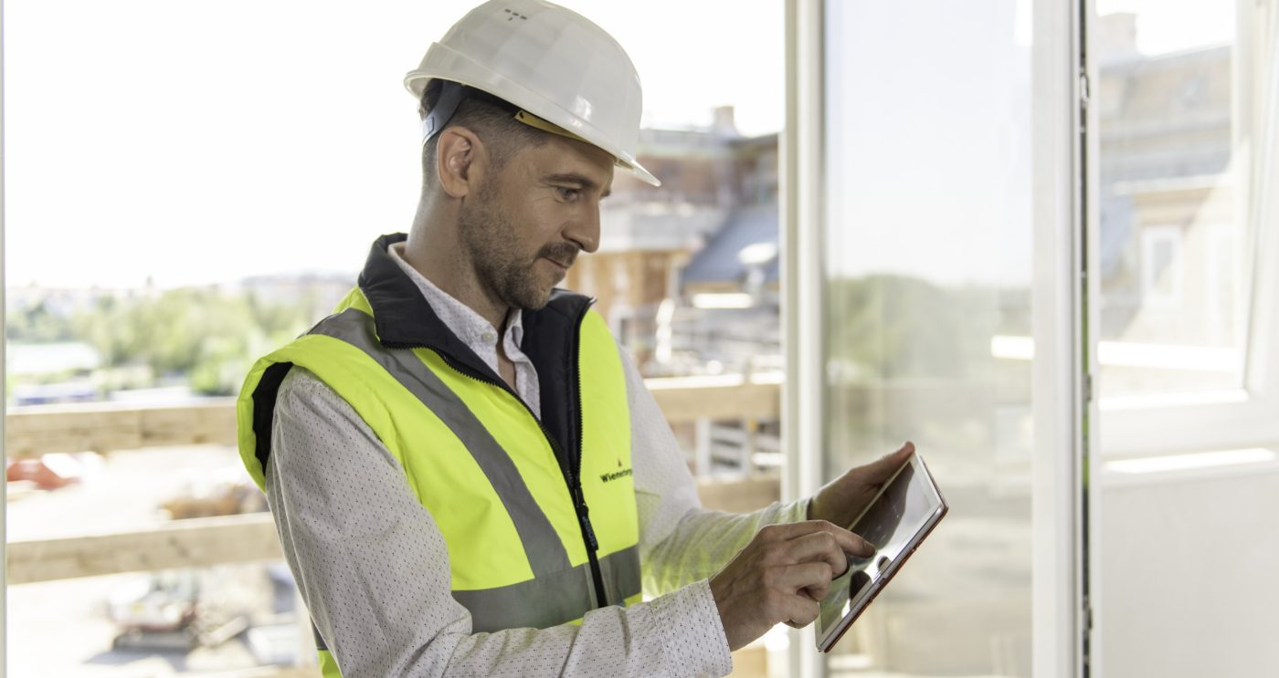 Architect or project manager using mobile device at construction site