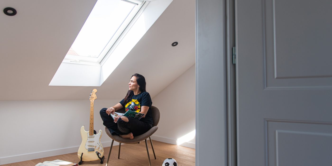 Djevojka koja sjedi ispod Tondach krovnog prozora