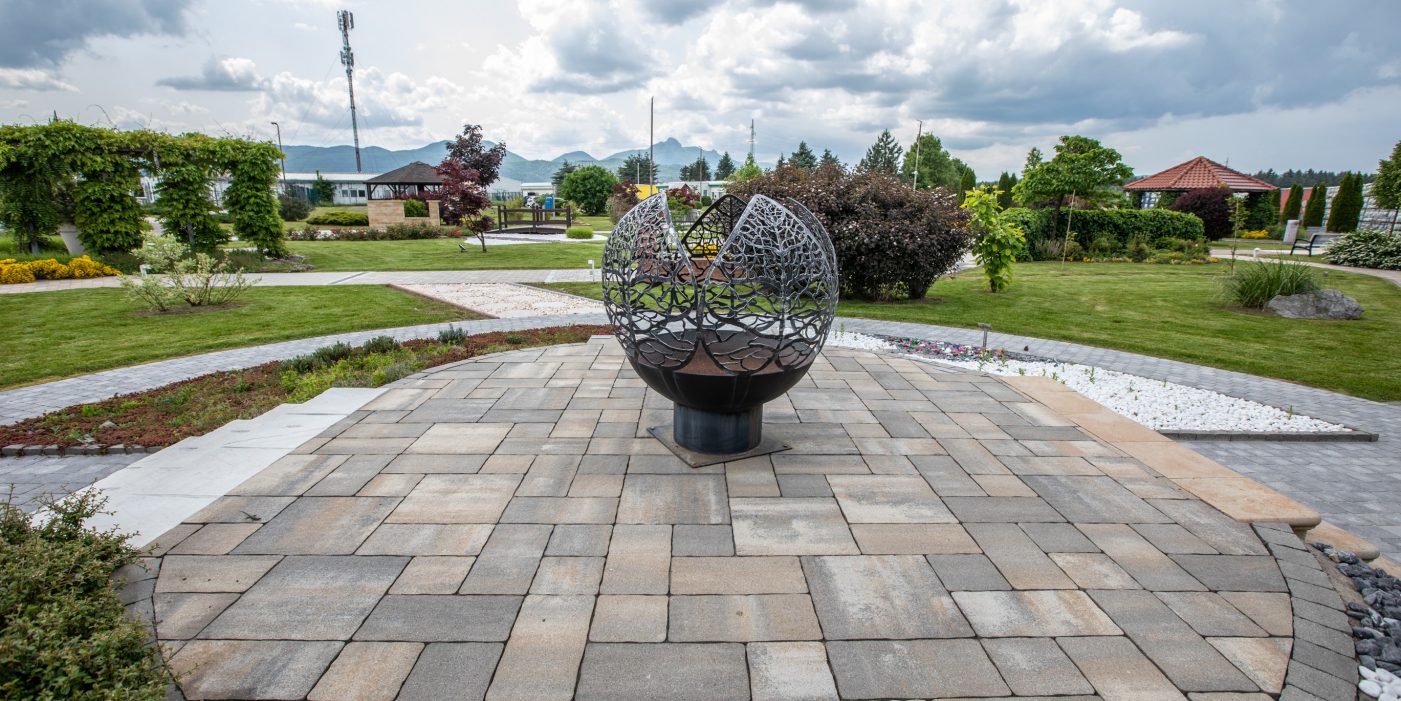 Semmelrock višebojni betonski opločnici u izložbenom vrtu Ogulin s ukrasnom skulpturom i uređenim zelenim površinama