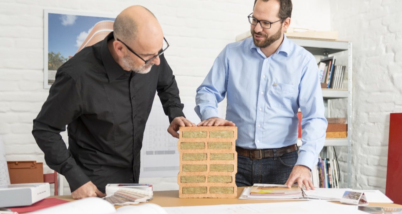 Architect and Wienerberger project manager talking about advantages of a mineral wool infilled clay block at architect's office