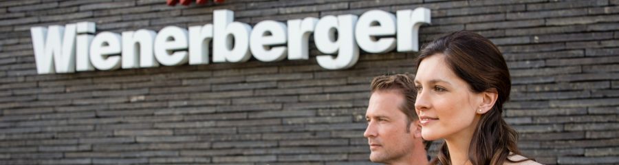 Couple standing outside the showroom Londerzeel near logo Wienerberger