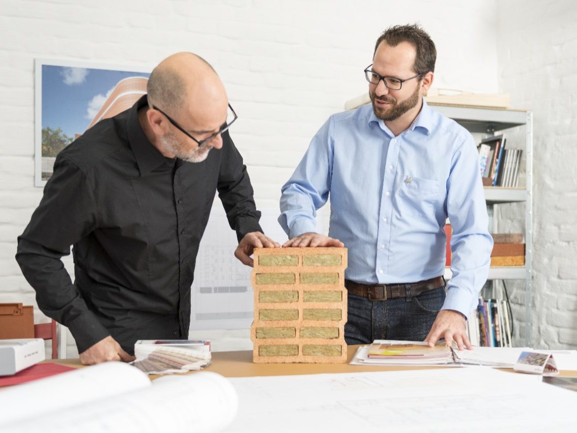 Architect and Wienerberger project manager talking about advantages of a mineral wool infilled clay block at architect's office