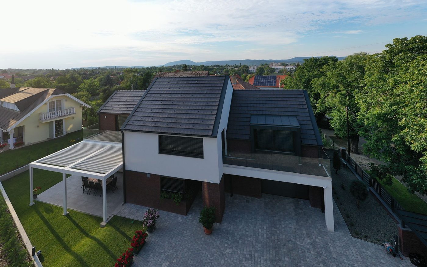 Tondach Planoton 10 crijep na modernoj obiteljskoj kući - pogled iz zraka s uređenim dvorištem