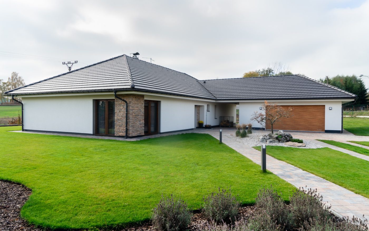 Tondach Planoton 10 crijep u antracit boji na prizemnoj obiteljskoj kući s garažom i uređenim travnjakom