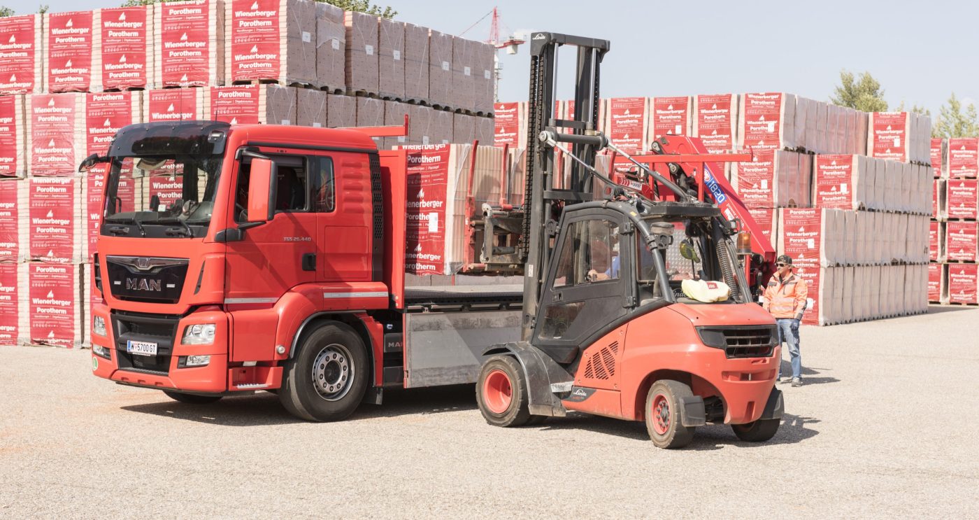 Forklift loads clay block pallets onto truck at stockyard