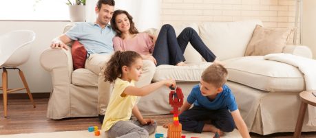 Parents watching children playing with miniature bricks and plastic building blocks