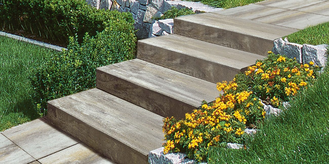 Semmelrock stepenice s imitacijom drvene teksture u bež-smeđim tonovima - vanjsko stepenište u urednom vrtu s cvijećem i kamenim rubnjacima