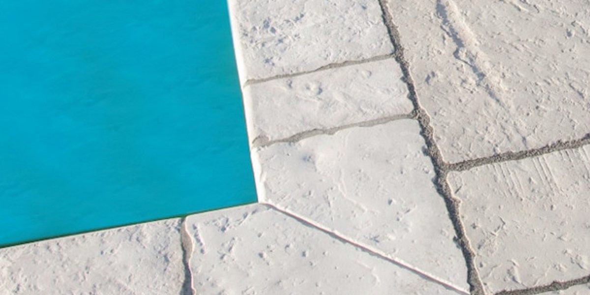 Semmelrock ploče za bazen, bijele rustikalne teksture uz rub bazena - detalj popločenja terasa oko bazena