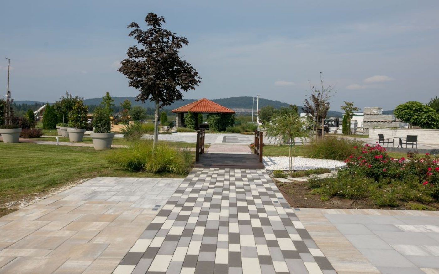 Semmelrock ploče i opločnici u sivim i bež tonovima - uređeni javni park s gazebom i zelenilom