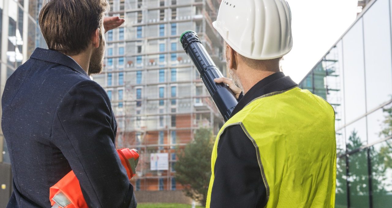 Businessman and architect talking about a new building project at a construction site