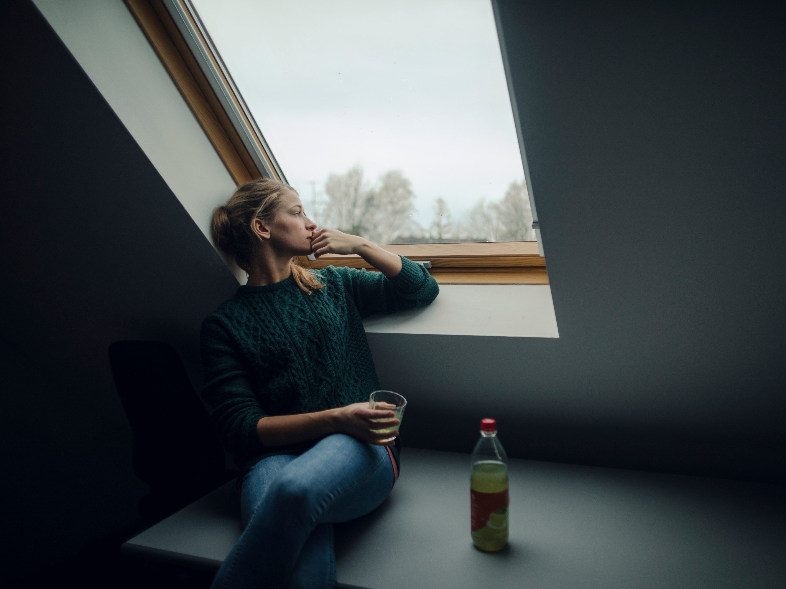 Zamišljena žena uz pogled s krovnog prozora