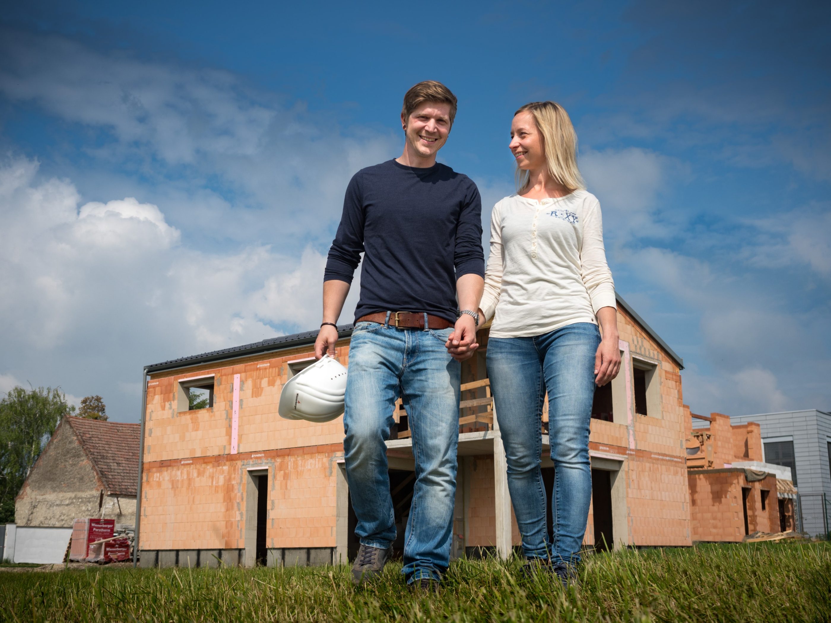 Porotherm Profi brušena opeka na gradilištu obiteljske kuće - obitelj obilaze kuću zidanu brušenom ciglom